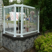 Brick retaining wall with white metal fence